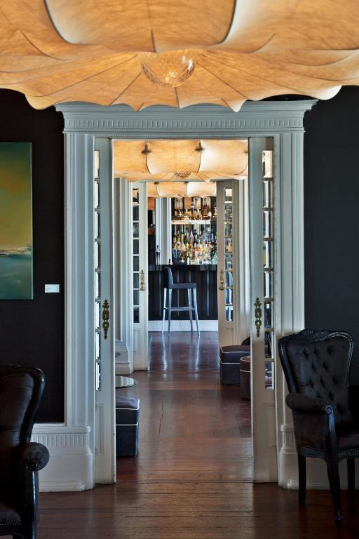 a living room with a bar with a wooden ceiling at Farol Hotel in Cascais