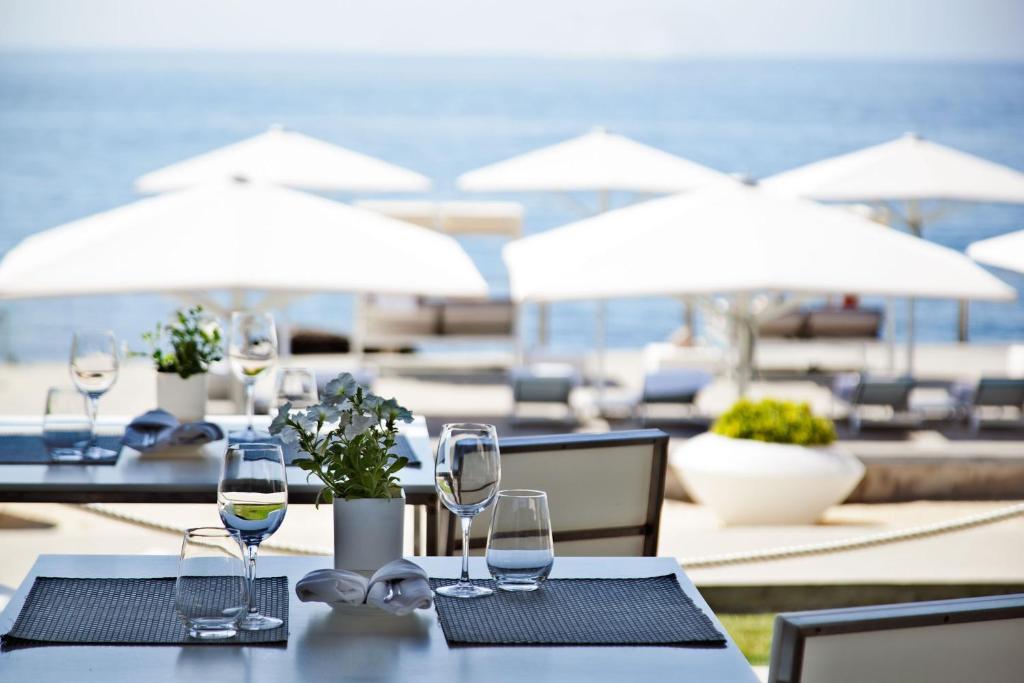 a table with glasses of wine on a beach at Farol Hotel in Cascais