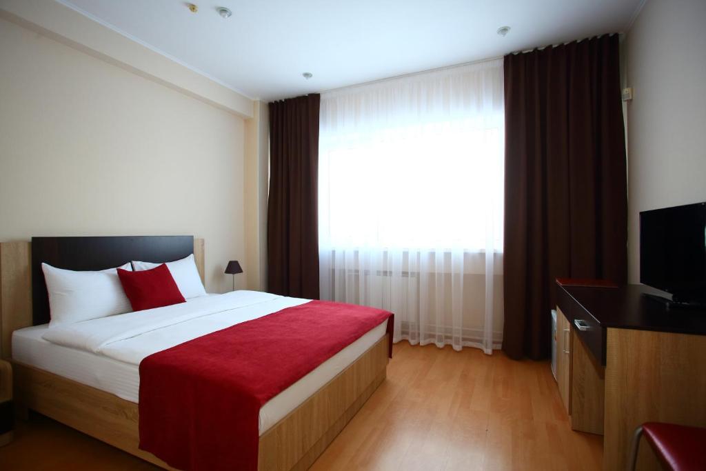 a hotel room with a bed and a television at Maksim Hotel in Yekaterinburg