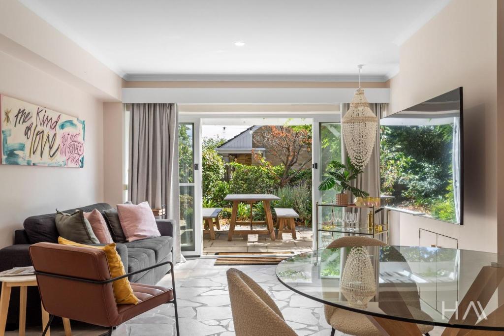 a living room with a glass table at Rose Gold Hideaway in Kings Park