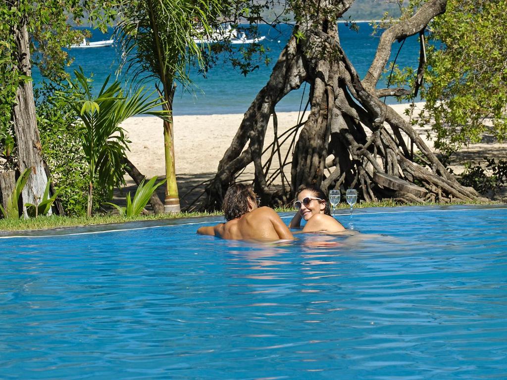 two people in the water in a swimming pool at Ocho Artisan Bungalows in Tamarindo