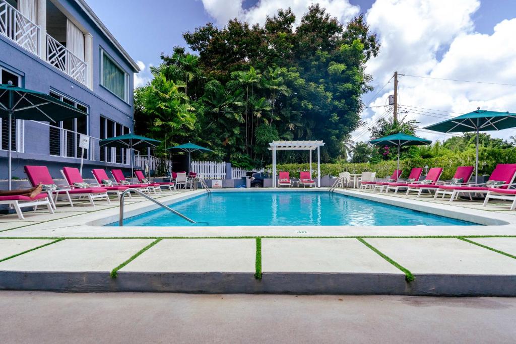 a swimming pool with lounge chairs and a building at The Palms Resort in Saint James