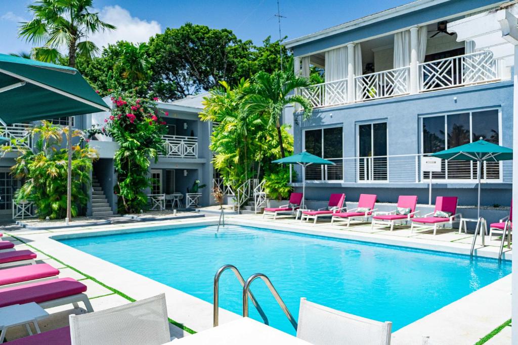 a pool in front of a hotel with chairs and umbrellas at The Palms Resort in Saint James