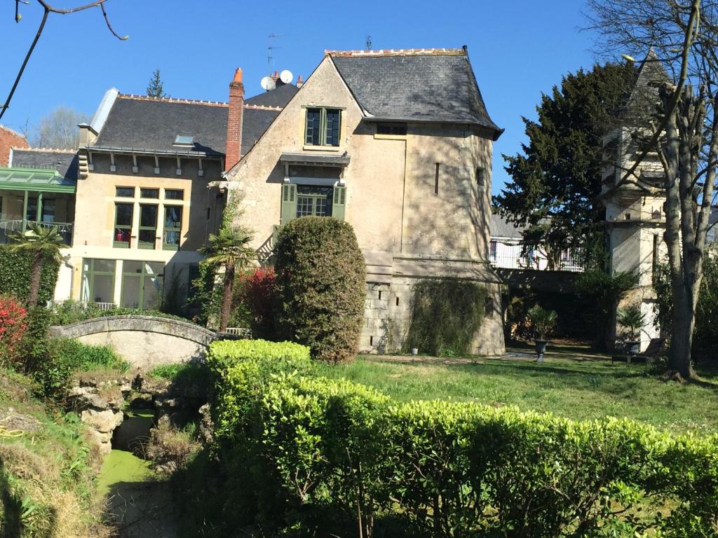 une vieille maison avec un pont devant elle dans l'établissement Loire Valley Medieval Getaway, à Rochecorbon