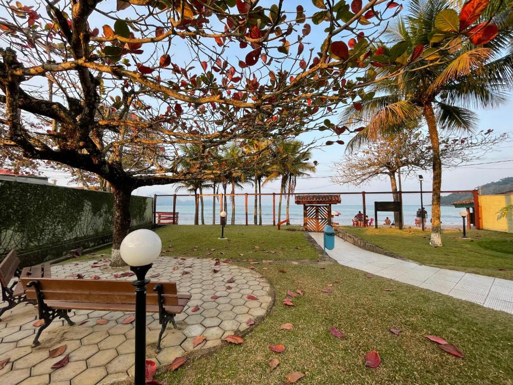 a park with a bench and a view of the ocean at Pé na Areia Praia das Toninhas - Villagio 17 in Ubatuba