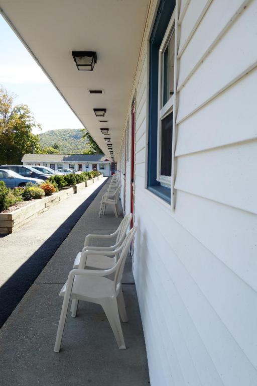 a row of chairs sitting on the side of a building at Monument Mountain Motel in Great Barrington