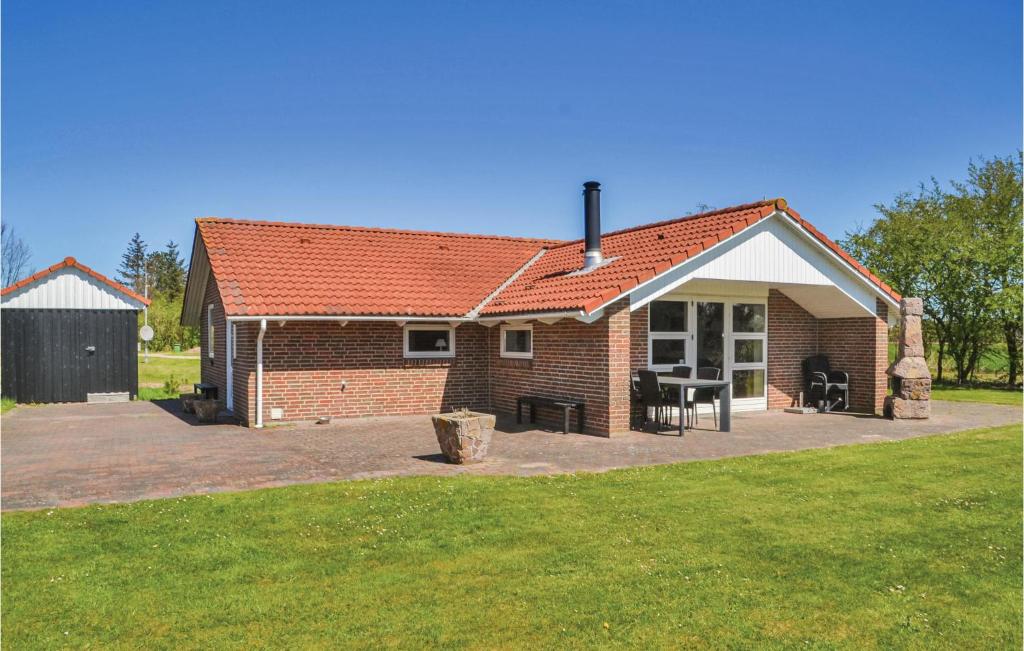 a brick house with a picnic table in front of it at Holiday Home Hindbærvangen Oksbøl V in Oksbøl