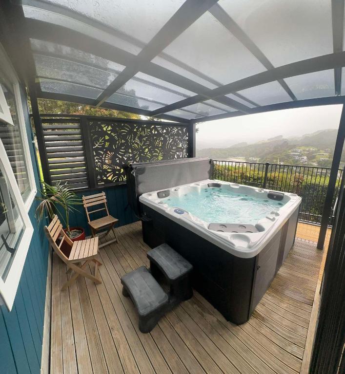 a hot tub on the deck of a house at Coromandel Seaview Motel in Coromandel Town