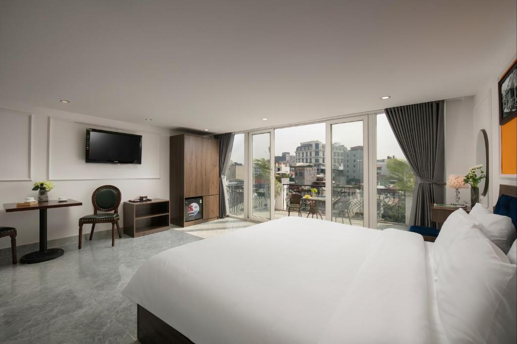a bedroom with a white bed and a large window at Dream Premium Hotel & Spa in Hanoi