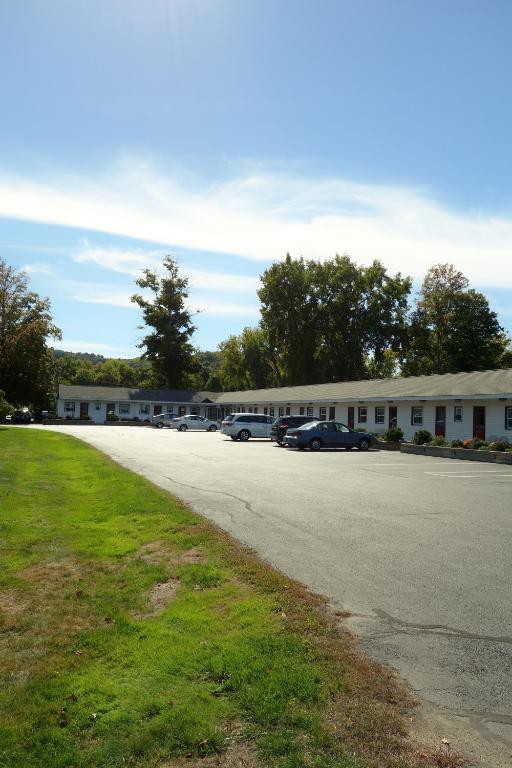 a building with cars parked in a parking lot at Monument Mountain Motel in Great Barrington