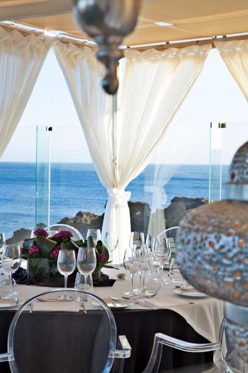 a table with wine glasses and a view of the ocean at Farol Hotel in Cascais