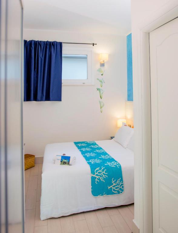 a bedroom with a white bed and a window at Hotel La Villa Del Mare in Cagliari