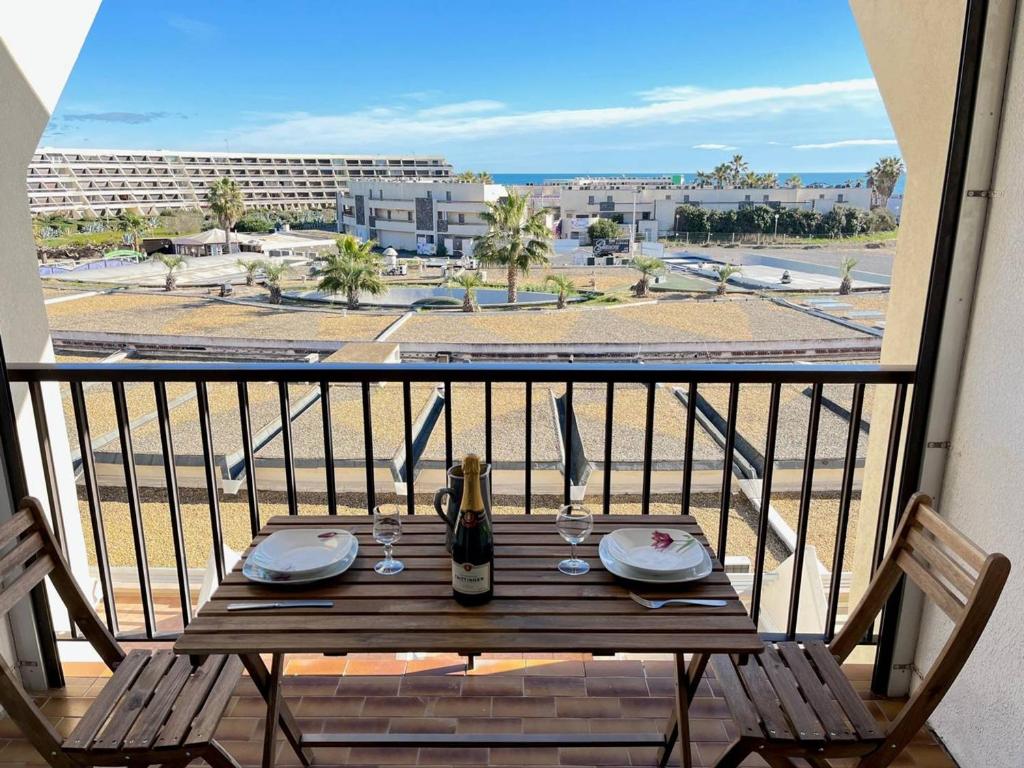 - une table sur un balcon avec vue sur la rue dans l'établissement Studio naturiste bord de mer, terrasse sud, clim, parking - FR-1-249A-44, au Cap d'Agde