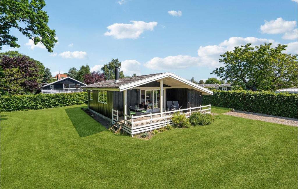 a small green house with a large yard at Holiday Home Humlevænget Iii in Hejls
