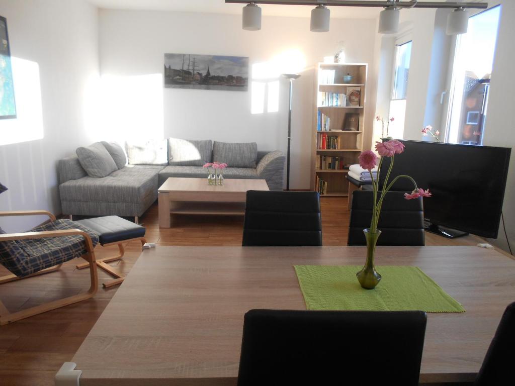 ein Wohnzimmer mit einer Blumenvase auf dem Tisch in der Unterkunft Ferienwohnung Parkgarten in Flensburg
