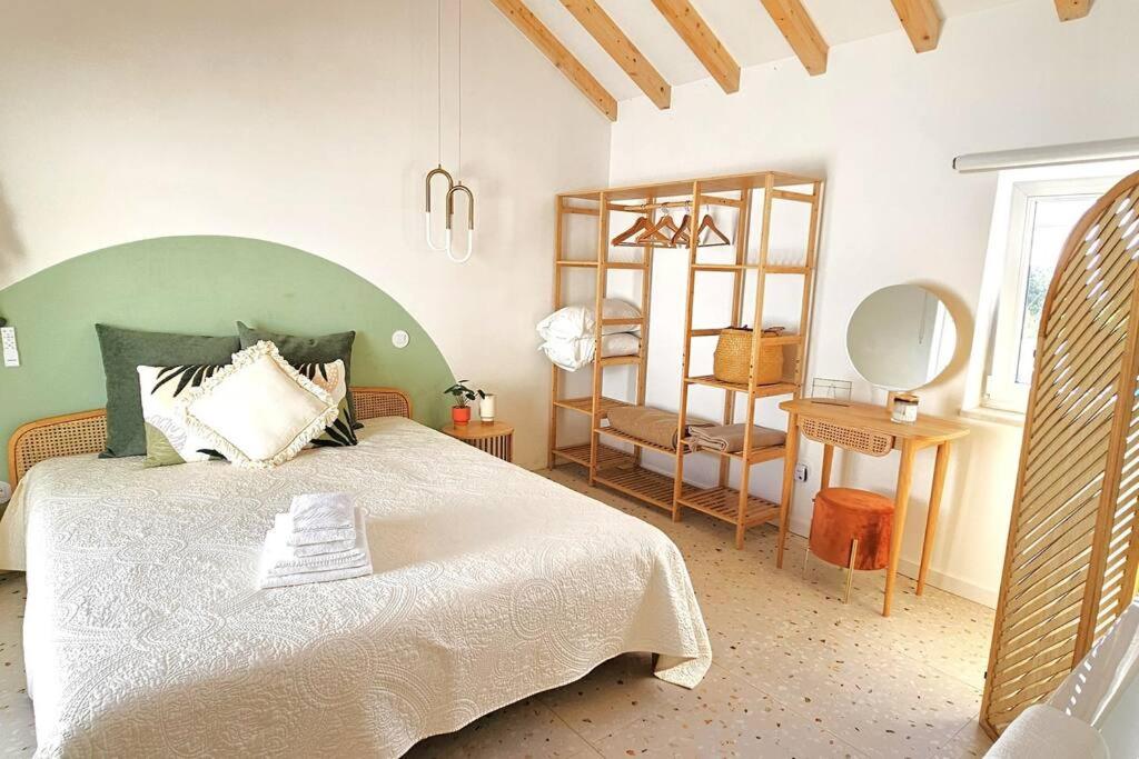 a bedroom with a large bed with a green headboard at Retreat yourself in Cozy vibes & so much to Discover in Alcobaça