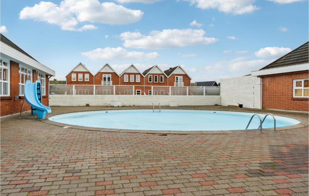 a swimming pool with a blue slide in a courtyard at Lejlighed 190 in Rømø