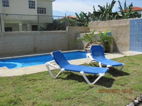 2 tumbonas junto a la piscina en Apartamentos Villa, en San Felipe de Puerto Plata