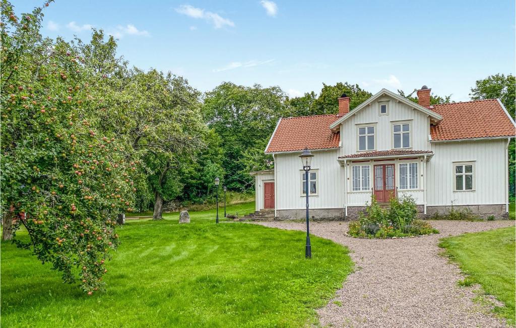 a white house with an apple tree in the yard at 4 Bedroom Stunning Home In Ödeshög in Ödeshög