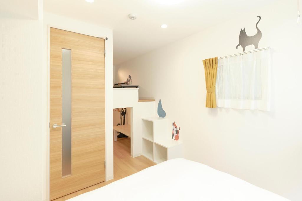 een kamer met een deur en een kat aan de muur bij Gaia BOSCO by Tranova in Tokyo