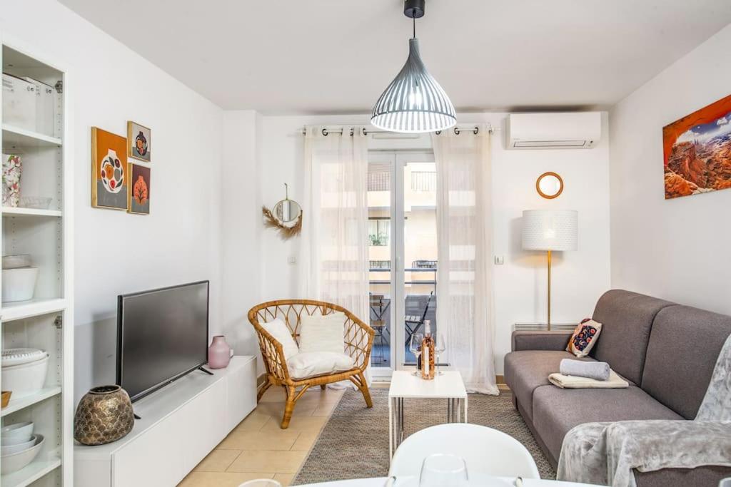 un salon avec un canapé et une télévision dans l'établissement Imperial plazza, à Menton