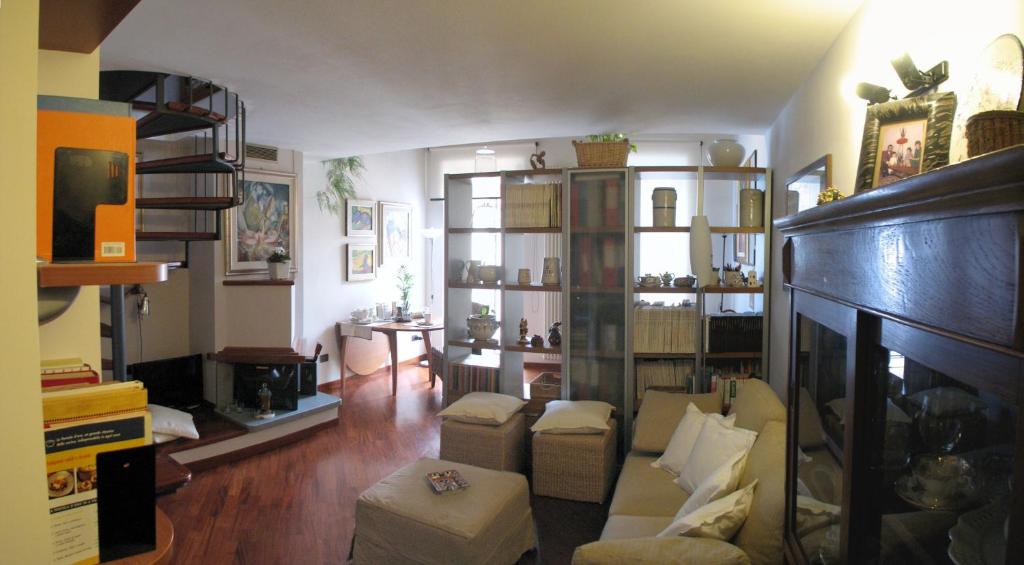uma sala de estar com um sofá e cadeiras num quarto em L'Abbaino em Campobasso
