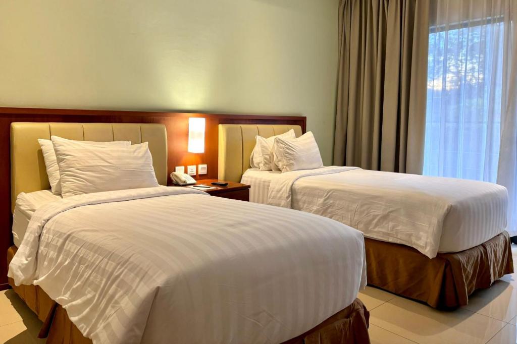 Letto o letti in una camera di Thong's Inn Hotel Kualanamu