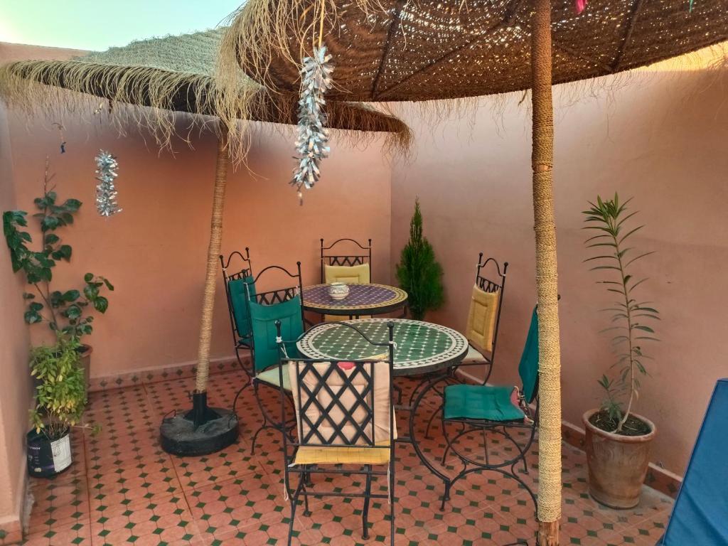 un patio avec une table, des chaises et un parasol dans l'établissement Riad Anisse, à Marrakech