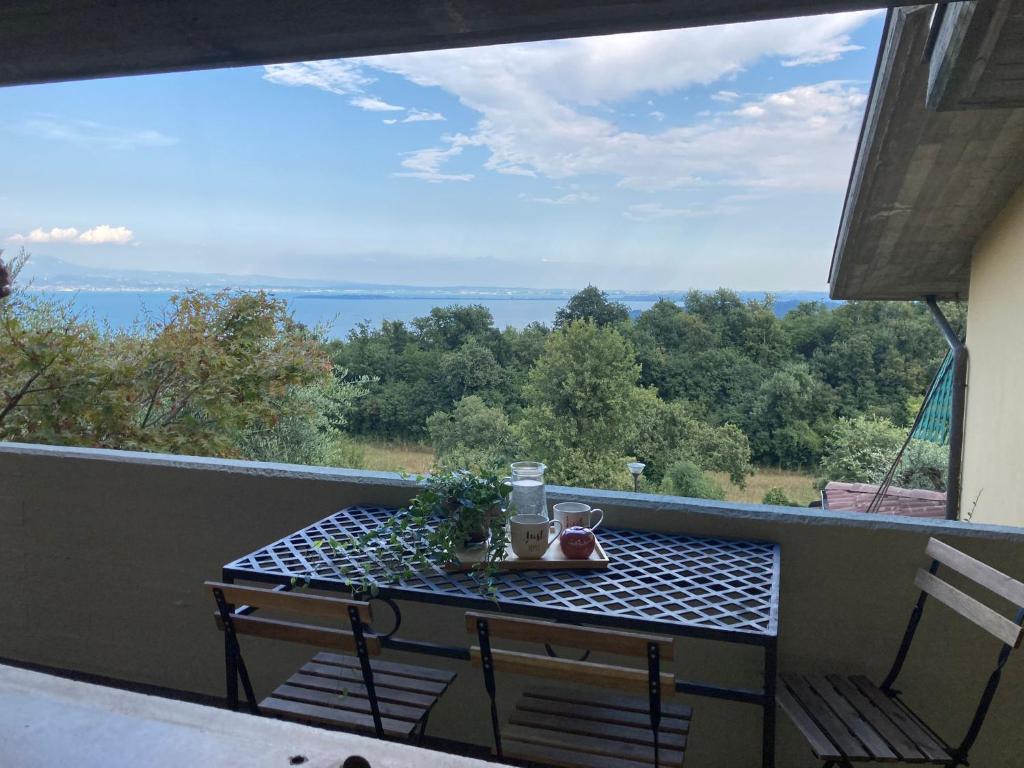 a table on a balcony with a view of the ocean at La casa di Trude in Padenghe sul Garda