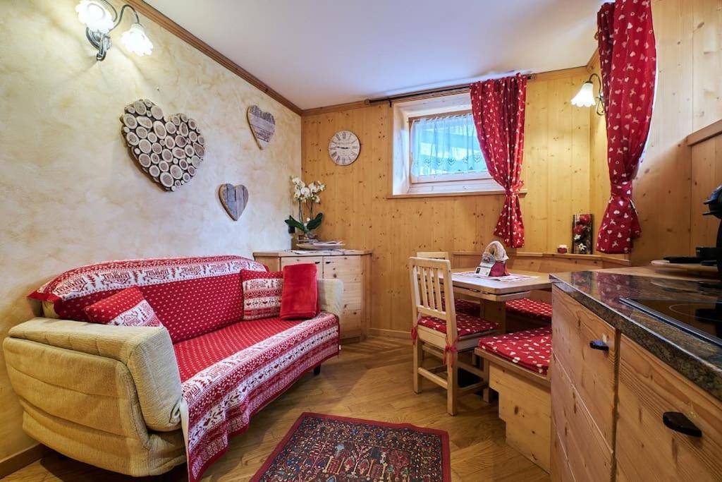 ein Wohnzimmer mit Sofa und Tisch in der Unterkunft L'appartamentino del cuore in Bormio