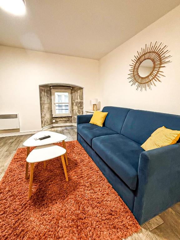 un salon avec un canapé bleu et une table dans l'établissement Le Cocon Rochelais, à La Rochelle