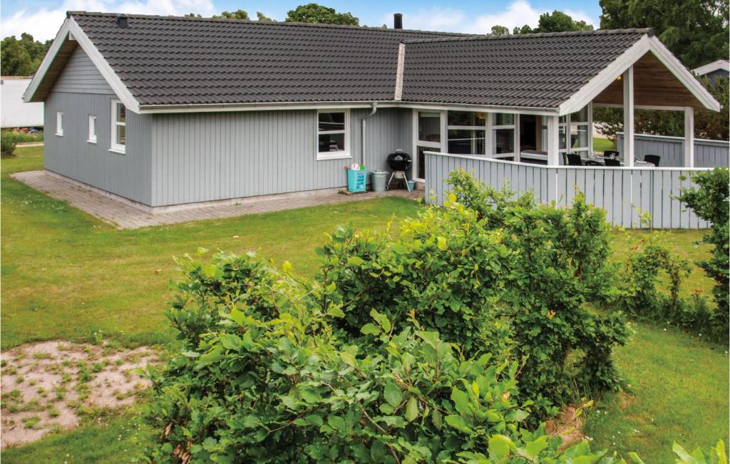a house with a fence in front of a yard at Holiday Home Marie Nielsens Vej Glesborg Denm in Fjellerup Strand