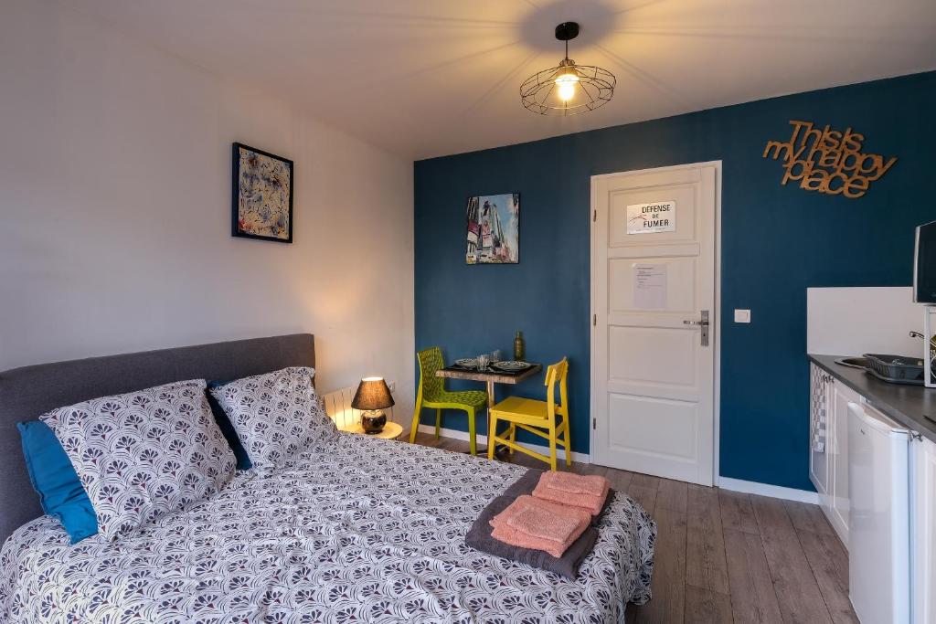 une chambre avec un lit et une cuisine avec une table dans l'établissement Le Studio de M.Hulot - Climatisé proche plage, à Saint-Nazaire