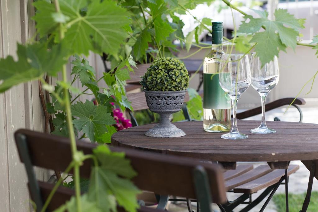 a wooden table with a bottle of wine and a plant at Kúria Apartman Private Wellness in Budapest