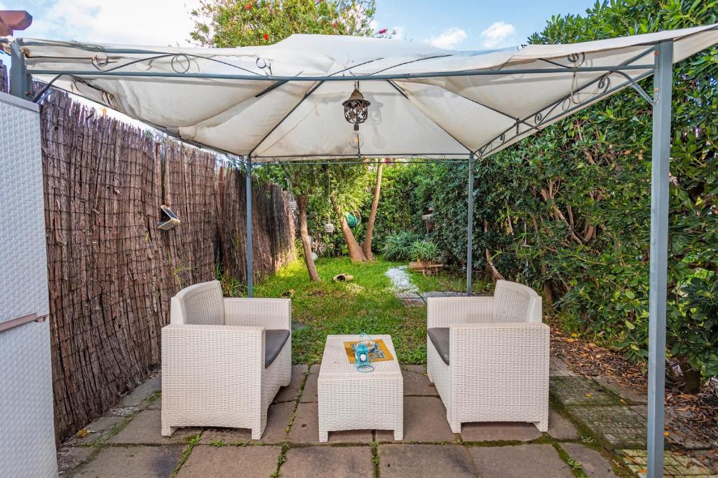 a patio with two chairs and a white umbrella at Marecalmo Holiday House Sea in Mascali