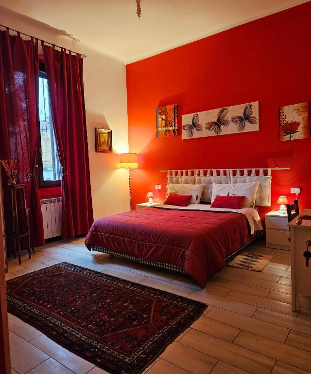 czerwona sypialnia z łóżkiem i czerwoną ścianą w obiekcie B&B Villa Emilia Milano w Mediolanie