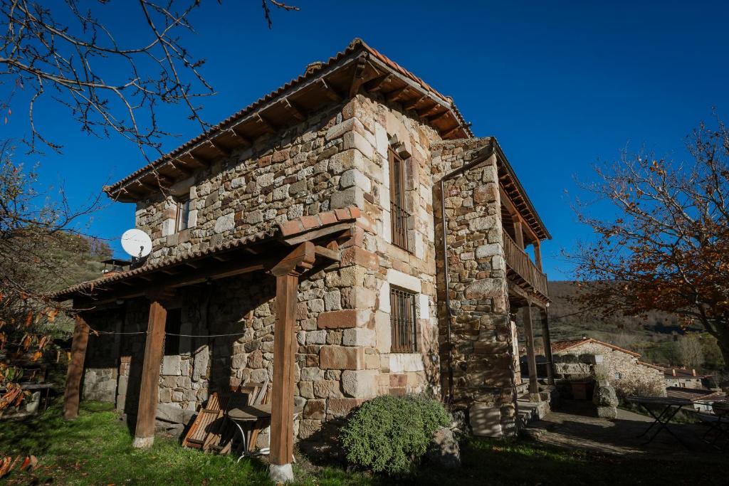 ein altes Steingebäude mit einer Uhr darauf in der Unterkunft El Casuco in Santa María de Redondo