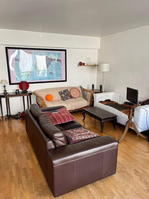 un salon avec un canapé et une table dans l'établissement 3 chambres terrasse et parking gratuit, à Paris