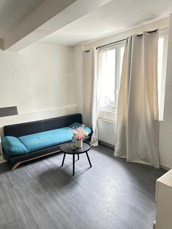 un salon avec un canapé bleu et une table dans l'établissement Iris, à Graulhet