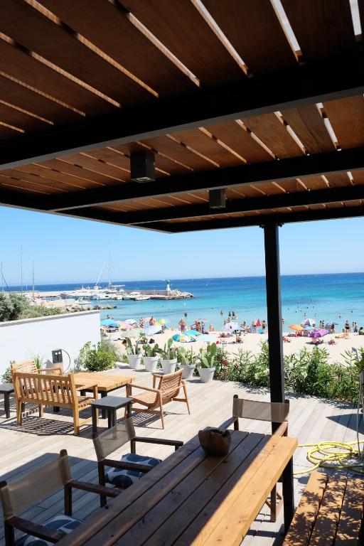 a patio with a table and chairs and a beach at Maison les pieds dans l'eau in Lumio