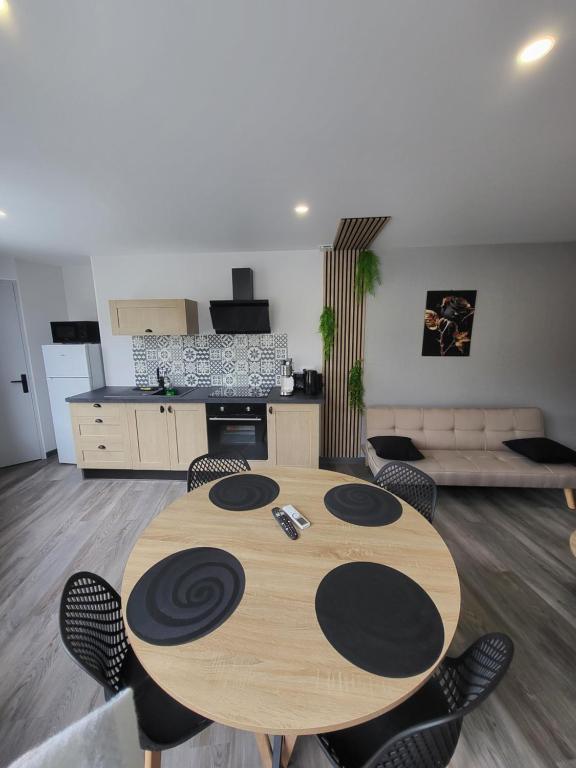 un salon avec une table et des chaises en bois dans l'établissement Cocon, à La Souterraine