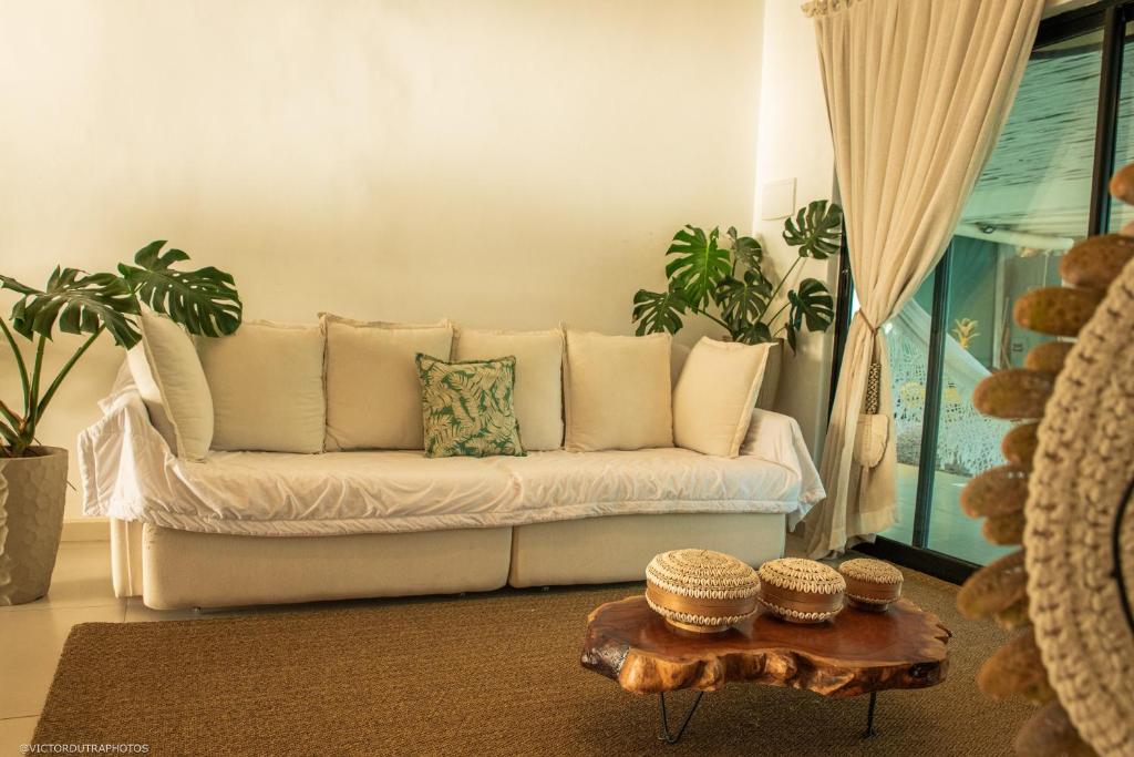 un soggiorno con un divano bianco e un tavolino da caffè di Pipa Sunset Home a Pipa