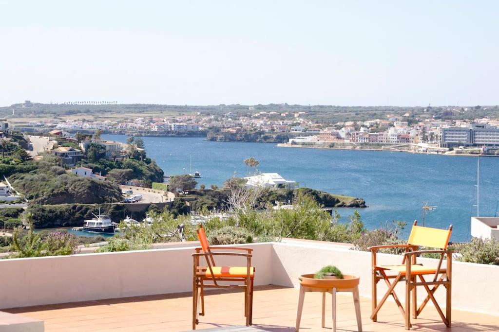 a group of chairs sitting on a deck with a view of the water at Bona Vista - Cala Llonga in Cala Llonga