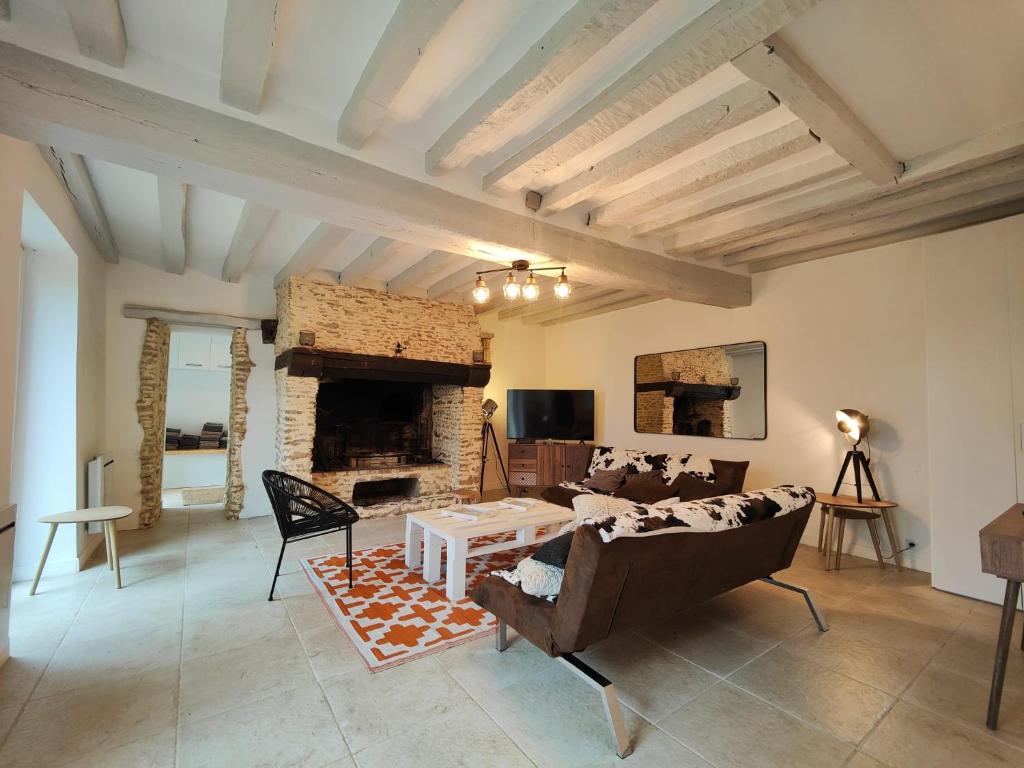 un salon avec un canapé et une cheminée dans l'établissement Charmante maison de campagne avec cheminée, à Souligné-Flacé