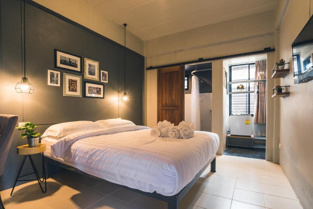 una camera da letto con un grande letto con lenzuola bianche di Cozy Inn Chiang Mai a Chiang Mai