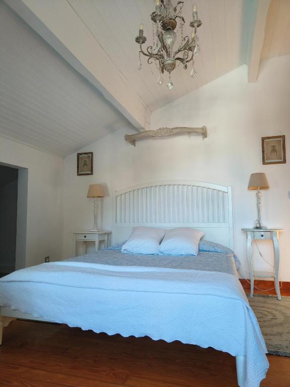 - une chambre dotée d'un lit avec des draps bleus et un lustre dans l'établissement Coqueto Apartamento en Hendaya, à Hendaye