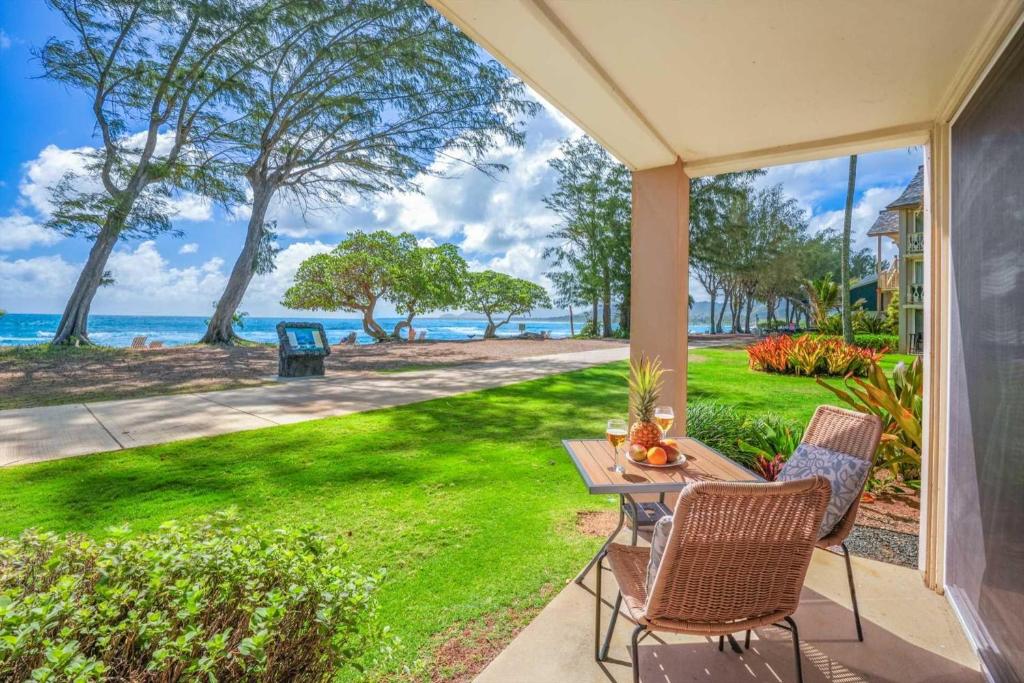 a patio with a table and chairs and the ocean at Islander on the Beach 154 in Kapaa