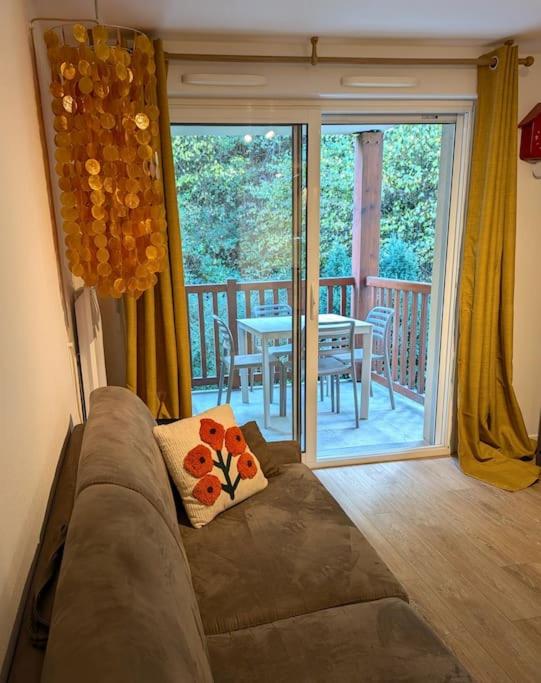 - un salon avec un canapé et une table sur un balcon dans l'établissement T2 chaleureux St Lary village, à Saint-Lary-Soulan