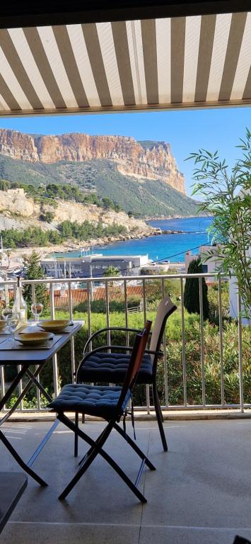 une table et des chaises sur un balcon avec vue sur l'océan dans l'établissement Blue note, à Cassis