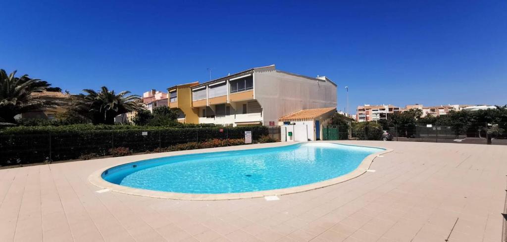 une piscine devant un immeuble dans l'établissement Cap d'Agde bord de mer, au Cap d'Agde